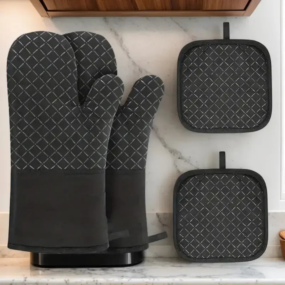 A set of four heat resistant silicone oven gloves and pot pads in black with a diamond pattern displayed on a kitchen counter