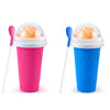 Two plastic cups for a DIY slushy maker, one pink and one blue, with spoons.