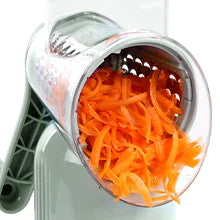 A silver rotary grater and slicer tool filled with shredded orange carrots.