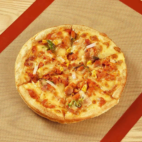 Eine runde Pizza mit Fleisch, Gemüse und geschmolzenem Käse liegt auf einer geflochtenen Matte.