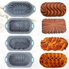 A set of silicone baking trays in various shapes and colors, including dark gray and brown, for versatile cooking.
