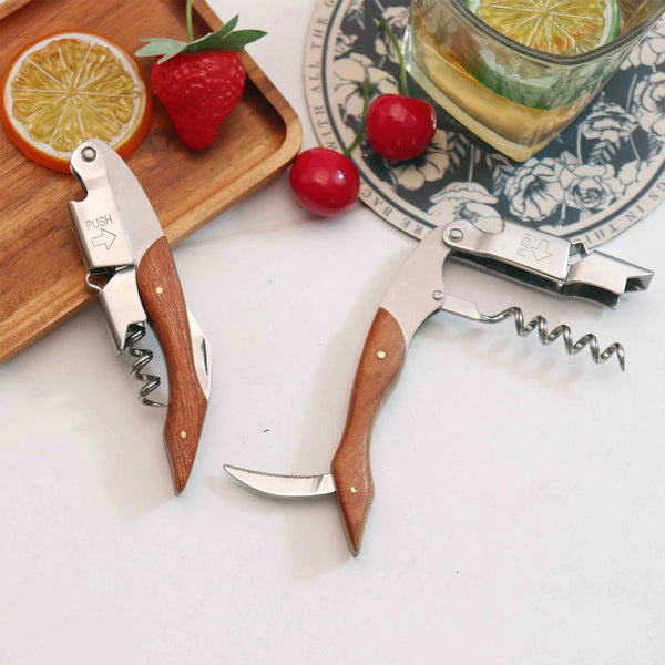 A professional wine opener with a wooden handle is shown next to fruit and a citrus slice.
