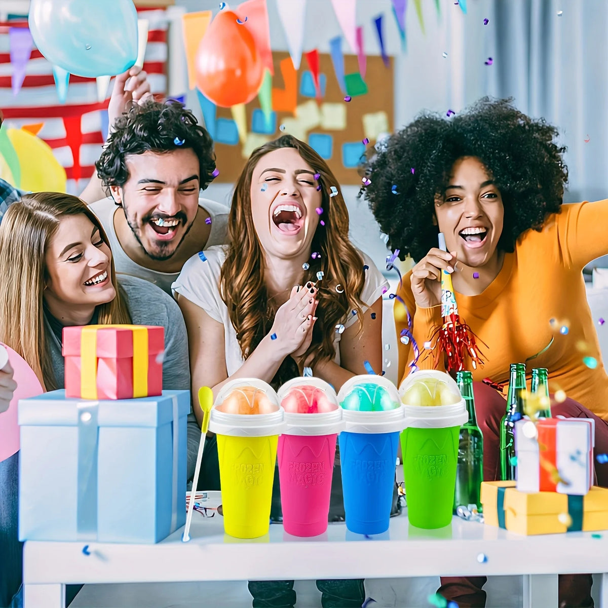 A group of four people laughing while holding colorful DIY slushy maker cups and balloons.