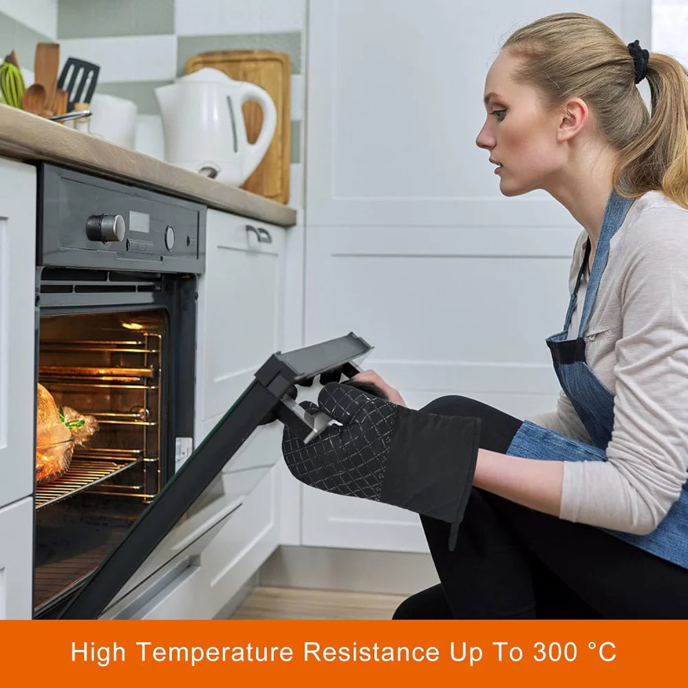 A woman wearing a blue apron is using black heat resistant silicone oven gloves to handle a dark oven.