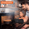 A man is using heat resistant silicone oven gloves to handle a pan inside a modern oven.