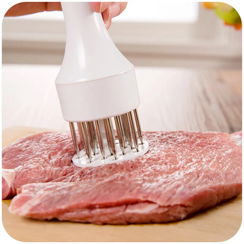 A hand is using a white meat tenderizer and flavor injector to press into a raw cut of red meat on a wooden cutting board.