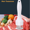 A white meat tenderizer tool is shown positioned over raw red meat, demonstrating its use for tenderizing.