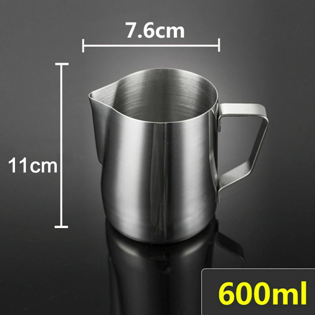 A stainless steel milk pitcher with a handle, shown against a dark background and with dimension markings.