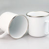 A white enamel mug with a silver rim and handle is shown against a light gray background.