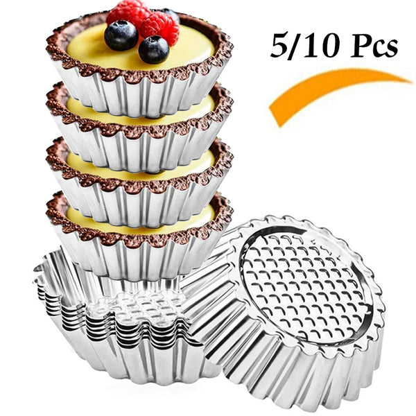 A stack of reusable stainless steel egg tart muffin molds with fresh berries on top.