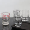 A set of clear glass measuring cups with etched volume markings for espresso and kitchen use.