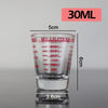 A clear glass measuring cup with volume markings, labeled 30ML, shown against a light gray background.