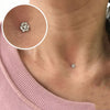 Close-up of a surgical steel dermal anchor body jewelry piece on a person's neck.