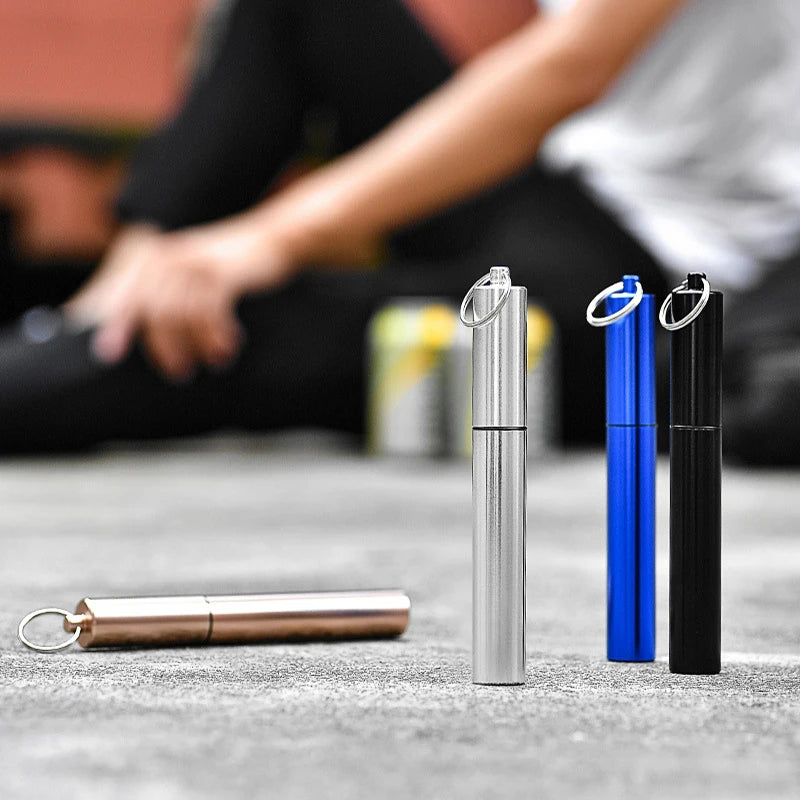 A set of stainless steel telescopic drinking straws in silver and blue with cleaning brushes displayed on a gray surface.