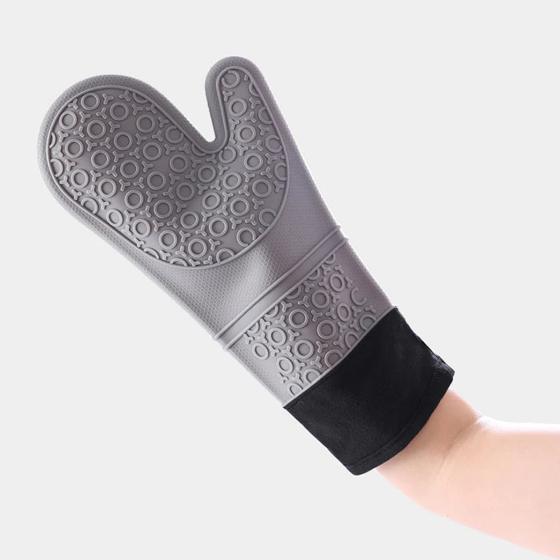 A close-up view of a gray heat resistant silicone oven mitt on a hand.