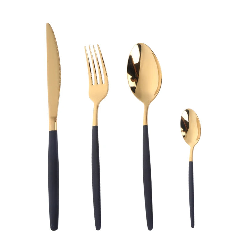 A set of elegant stainless steel flatware including a knife, fork, and spoon with gold-toned finishes and black handles.