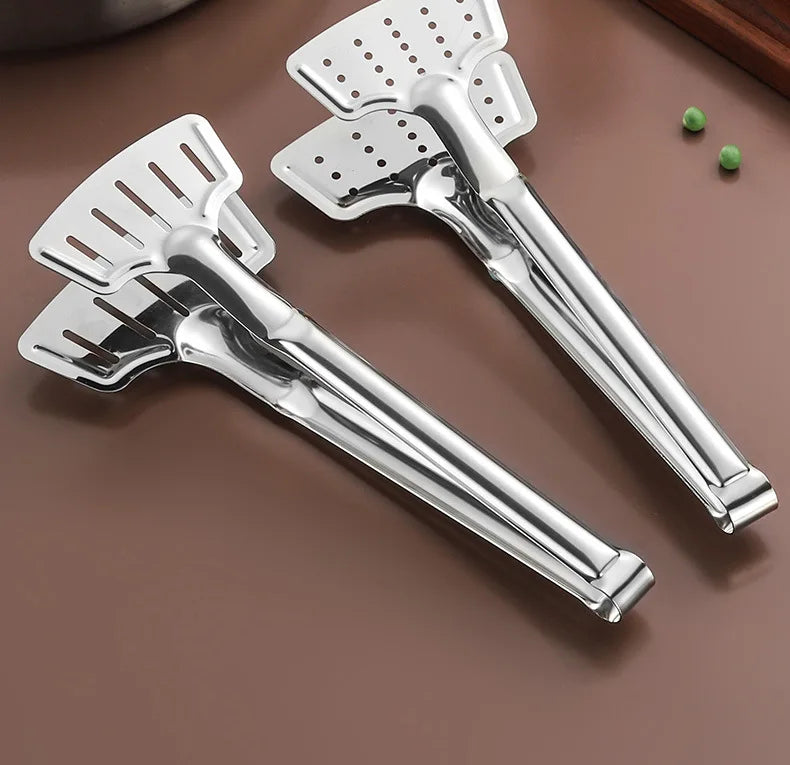A pair of stainless steel barbecue tongs resting on a brown surface.