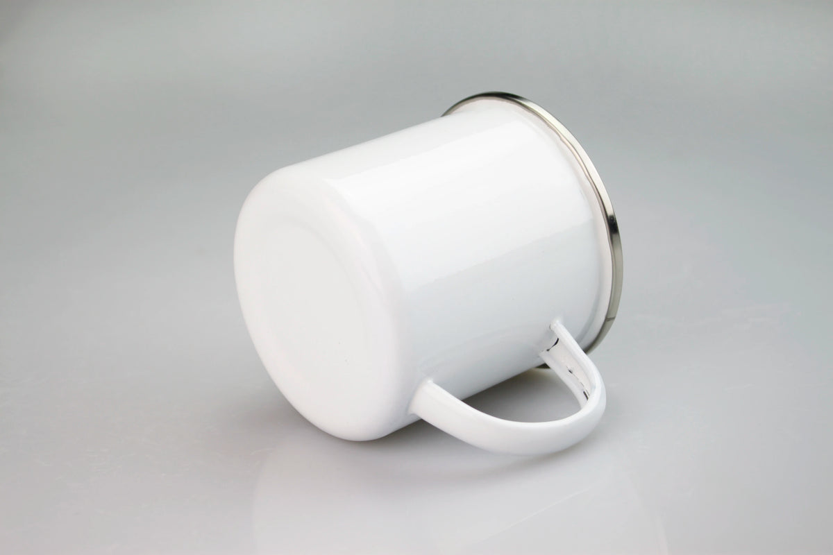 A white enamel mug with a silver rim and a white handle is shown against a light gray background.