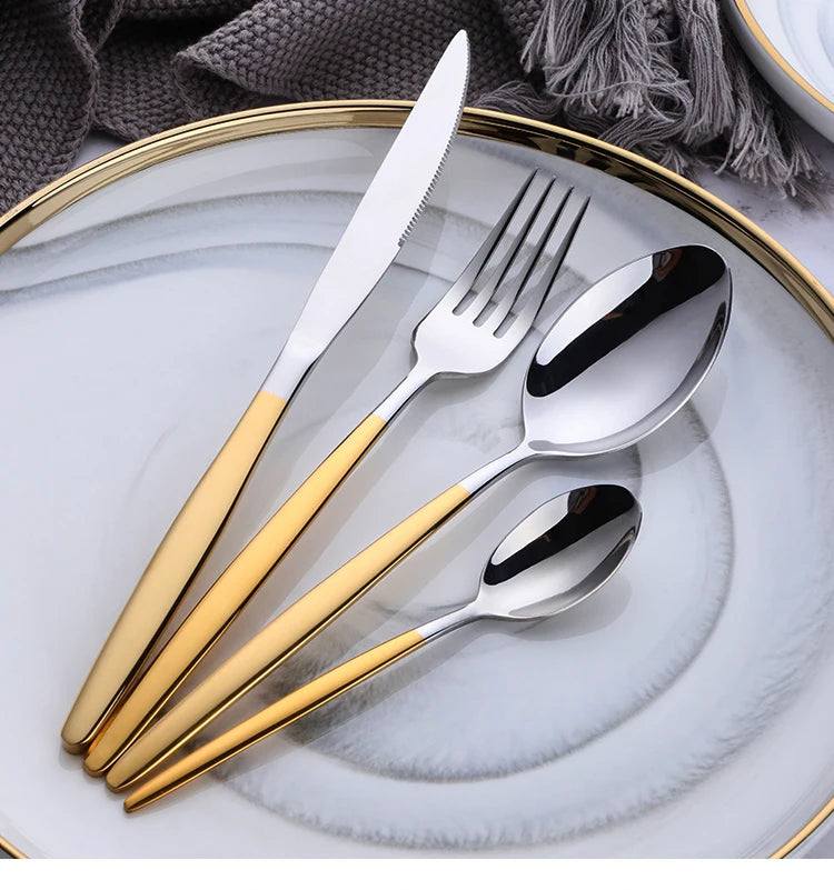 A set of elegant stainless steel flatware including a knife, fork, and spoon arranged on a white plate.