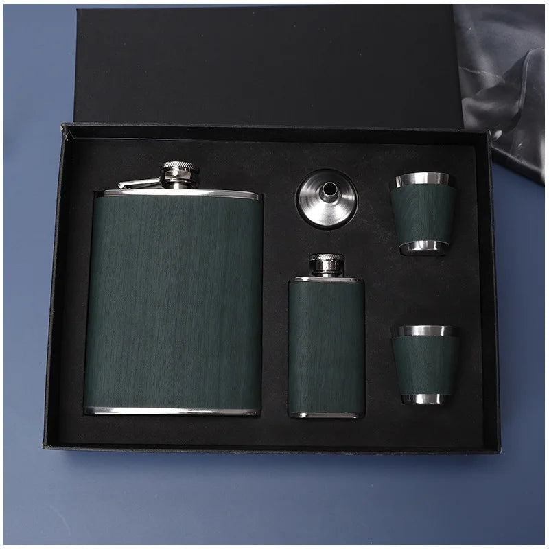 Una caja negra contiene un juego de frascos de acero inoxidable portátil con una botella principal y dos tazas más pequeñas.
