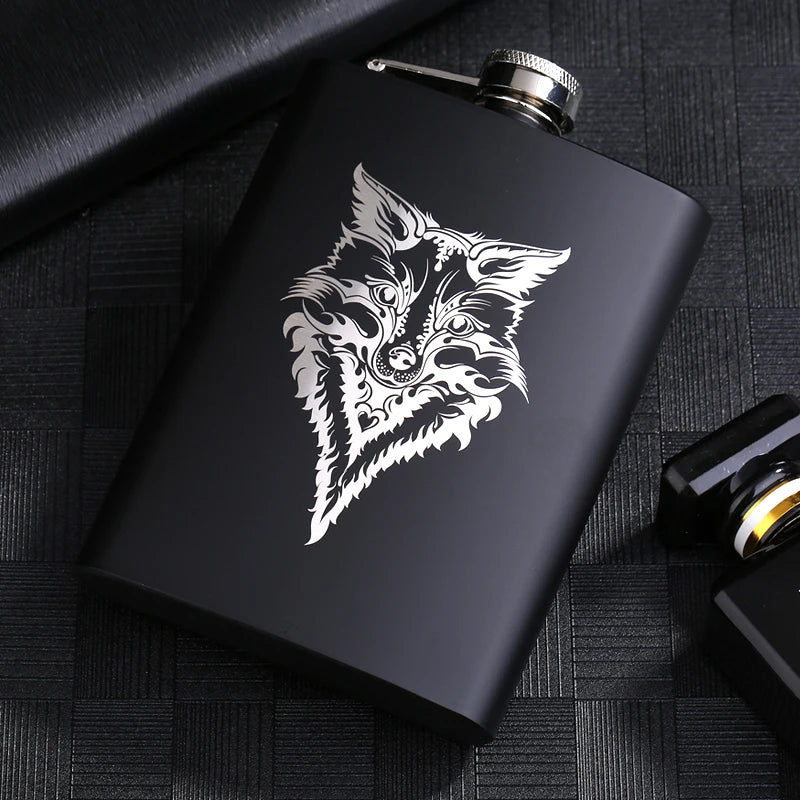A black laser engraved stainless steel hip flask featuring a detailed wolf head design.