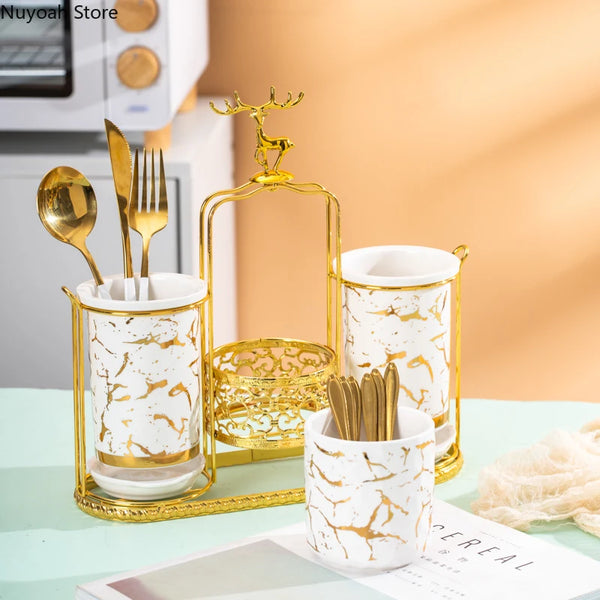 Luxuriertes goldenes Hirsch-Stäbchen-Abflussregal mit weiß-goldenen marmorierten Keramiktassen.