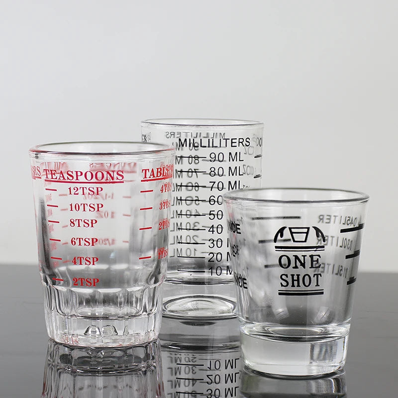 A collection of clear glass measuring cups for espresso and kitchen use, including various sizes.