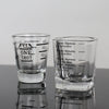 Two clear glass measuring cups with etched markings for espresso and kitchen use