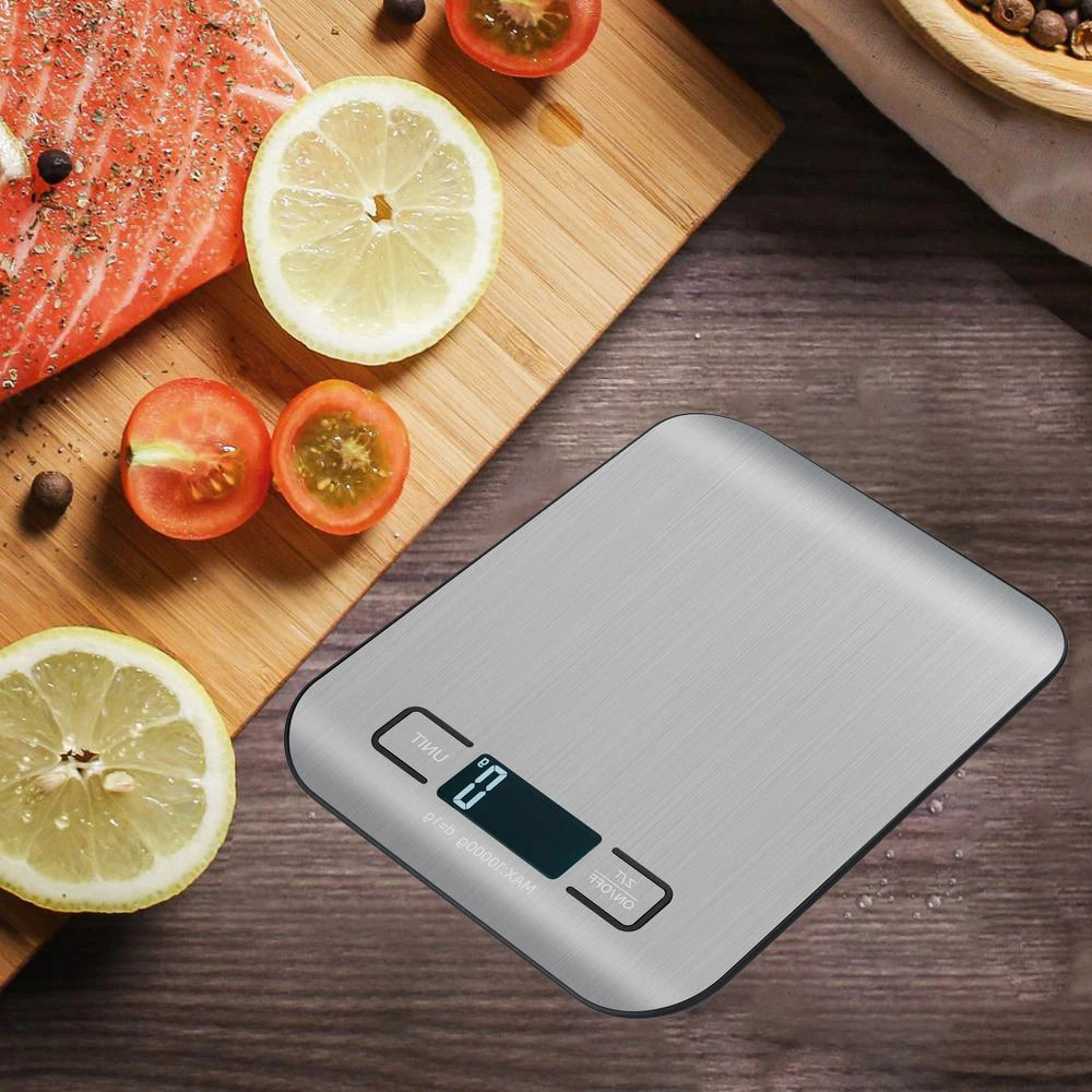 A stainless steel digital kitchen scale is placed on a wooden board next to fresh citrus fruits and salmon.