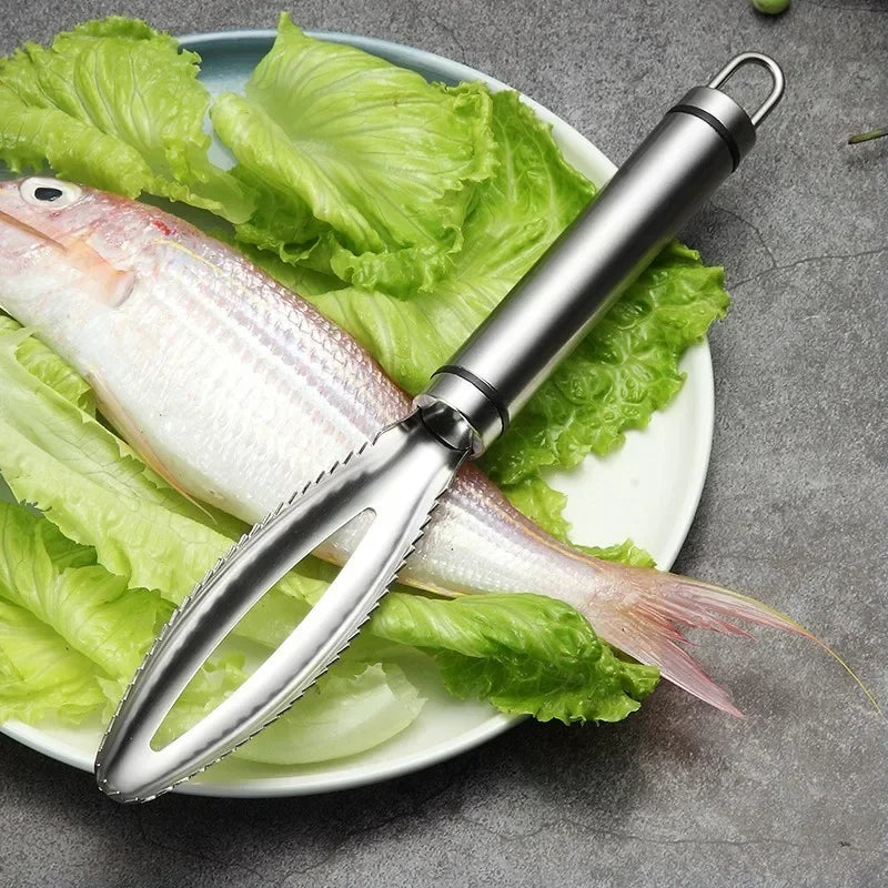 A stainless steel fish scale scraper and tweezers set resting on a plate with fresh lettuce.