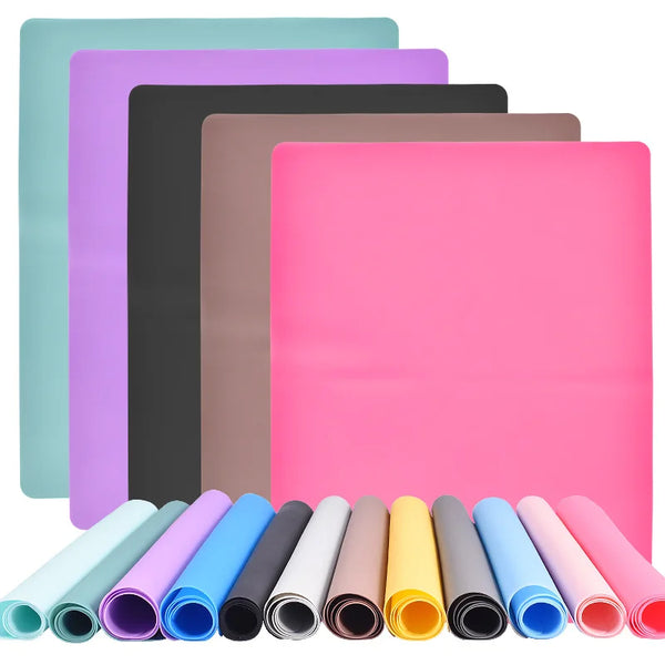 Eine Sammlung farbenfroher Silikon-Bastematten in verschiedenen Schattierungen, darunter rosa, lila, grün und schwarz.