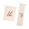 A beige linen bread bag with a drawstring featuring a stylized illustration of a bat and a sprig of wheat.