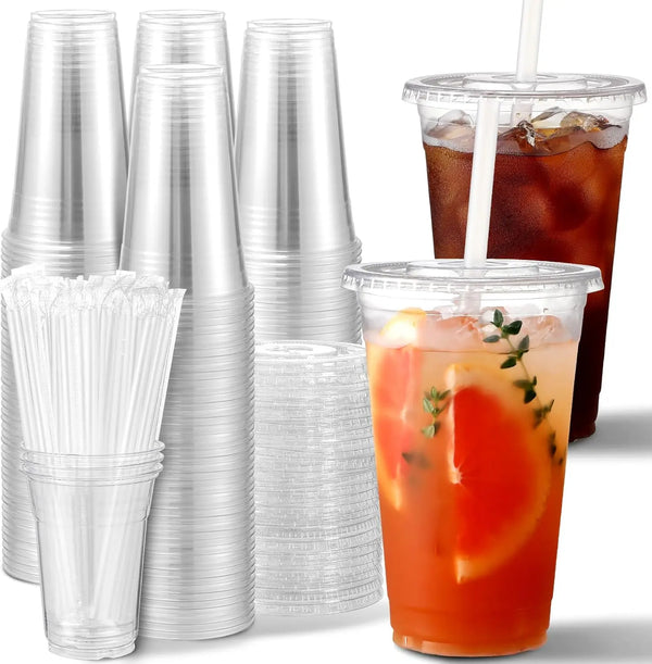 Eine Sammlung durchsichtiger Plastikbecher mit Deckeln und Strohhalmen, darunter mehrere aufrechte Becher und ein Getränk in 