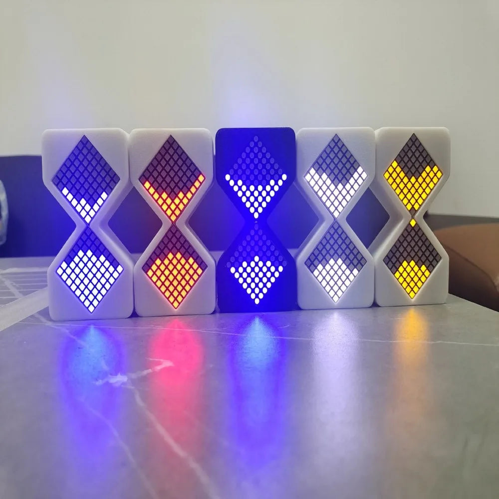 A row of eight white LED digital hourglass timers displaying various colors including blue, orange, and yellow light.