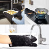 Black heat resistant baking gloves being used in a kitchen setting.