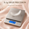 A silver digital kitchen scale displaying 0.1g precision, resting on a pink fabric.