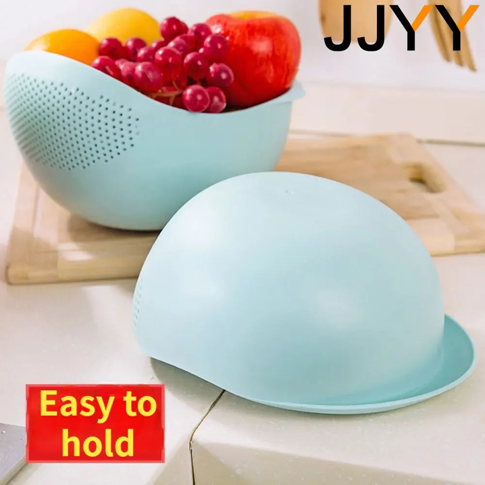 Light blue silicone colander and drainer set with fresh fruit on a wooden cutting board