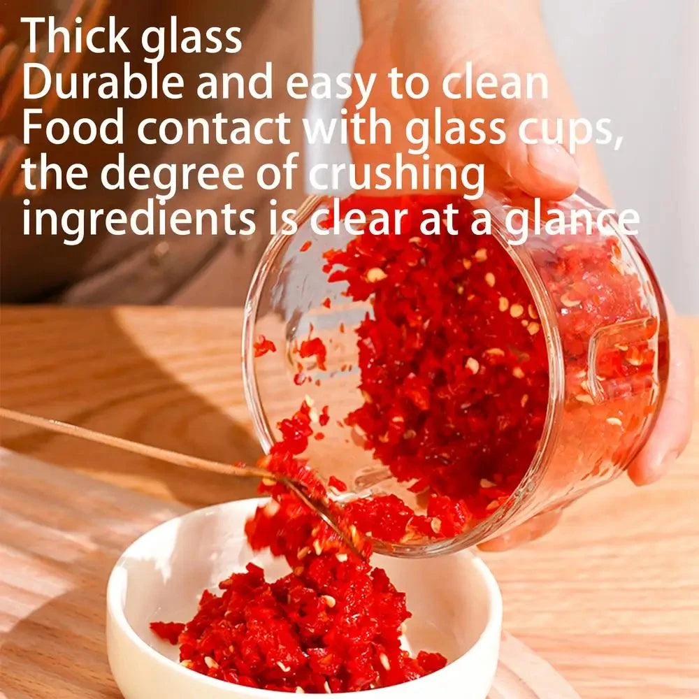 A hand pours bright red crushed ingredients from a glass cup into a white bowl.