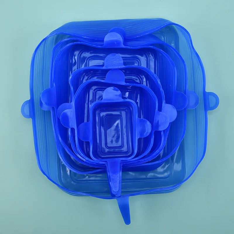 A clear blue reusable silicone food storage lid with multiple nested compartments.