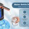 A hand dispenses water from a portable electric water bottle dispenser into a glass.