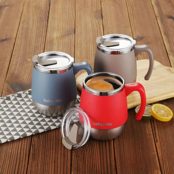 Drei vakuumisolierte Edelstahl-Kaffeetassen in Grau, Blau und Rot auf einer Holzoberfläche.