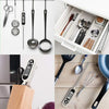 A collection of kitchen utensils, including a digital meat thermometer with a long probe, hanging on a rack.