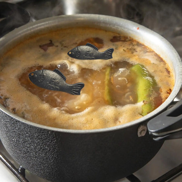 A black fish is visible in a simmering broth inside a dark pot.