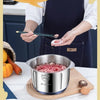 A hand is using a stainless steel electric meat grinder to process meat, with raw meat and garlic visible nearby.