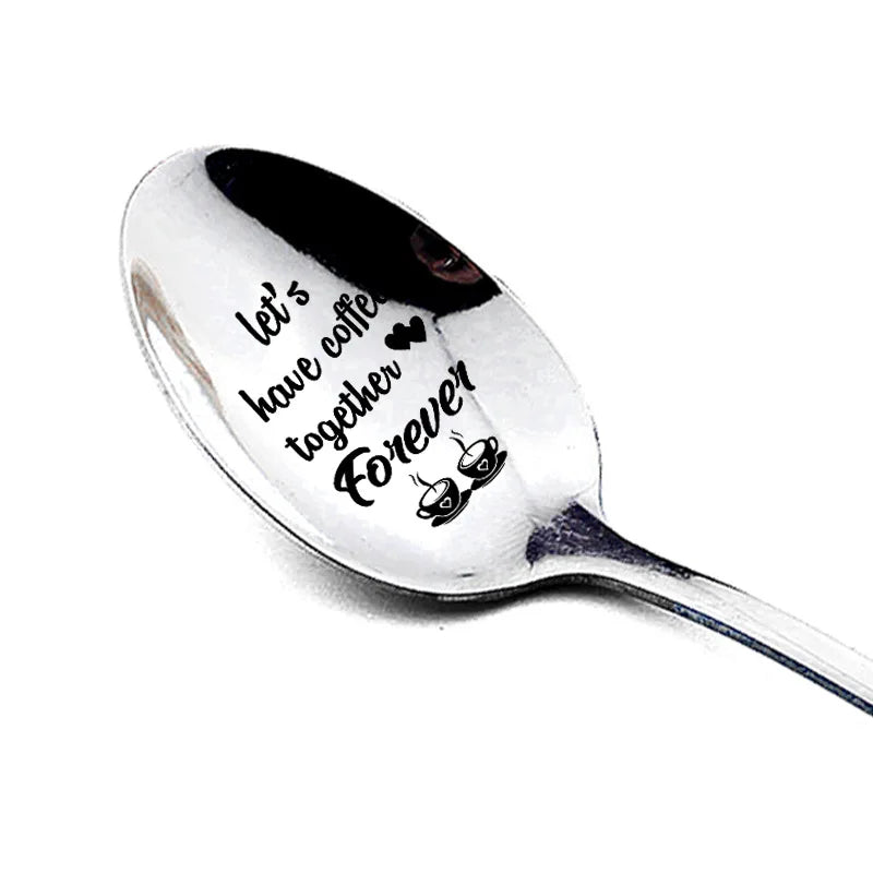 A silver stainless steel spoon engraved with the text Let's have coffee together Forever