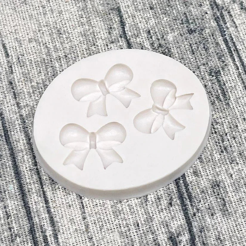 White silicone baking molds shaped like bows for chocolate cupcakes