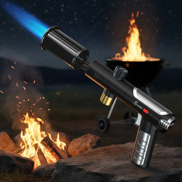 A black adjustable propane torch is shown in use, producing a bright flame outdoors near a campfire.