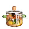 A large capacity borosilicate glass soup pot with a wooden lid filled with various vegetables and ingredients.