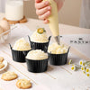Four reusable silicone egg poaching cups filled with fluffy yellow meringue or whipped cream on a white surface