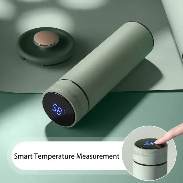 Ein modernes, zylindrisches Smart-Temperatursuchgerät in gedämpftem Grün neben seinem zerlegten oberen Teil.